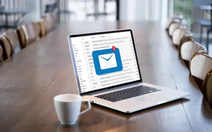 Laptop megnyitott levelezőprogrammal egy tárgyalóasztalon